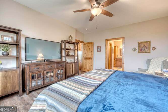 85 Minstead Ridge Young Harris, GA 30582 - Photo 8 of 50 a bedroom with a large bed and a chandelier