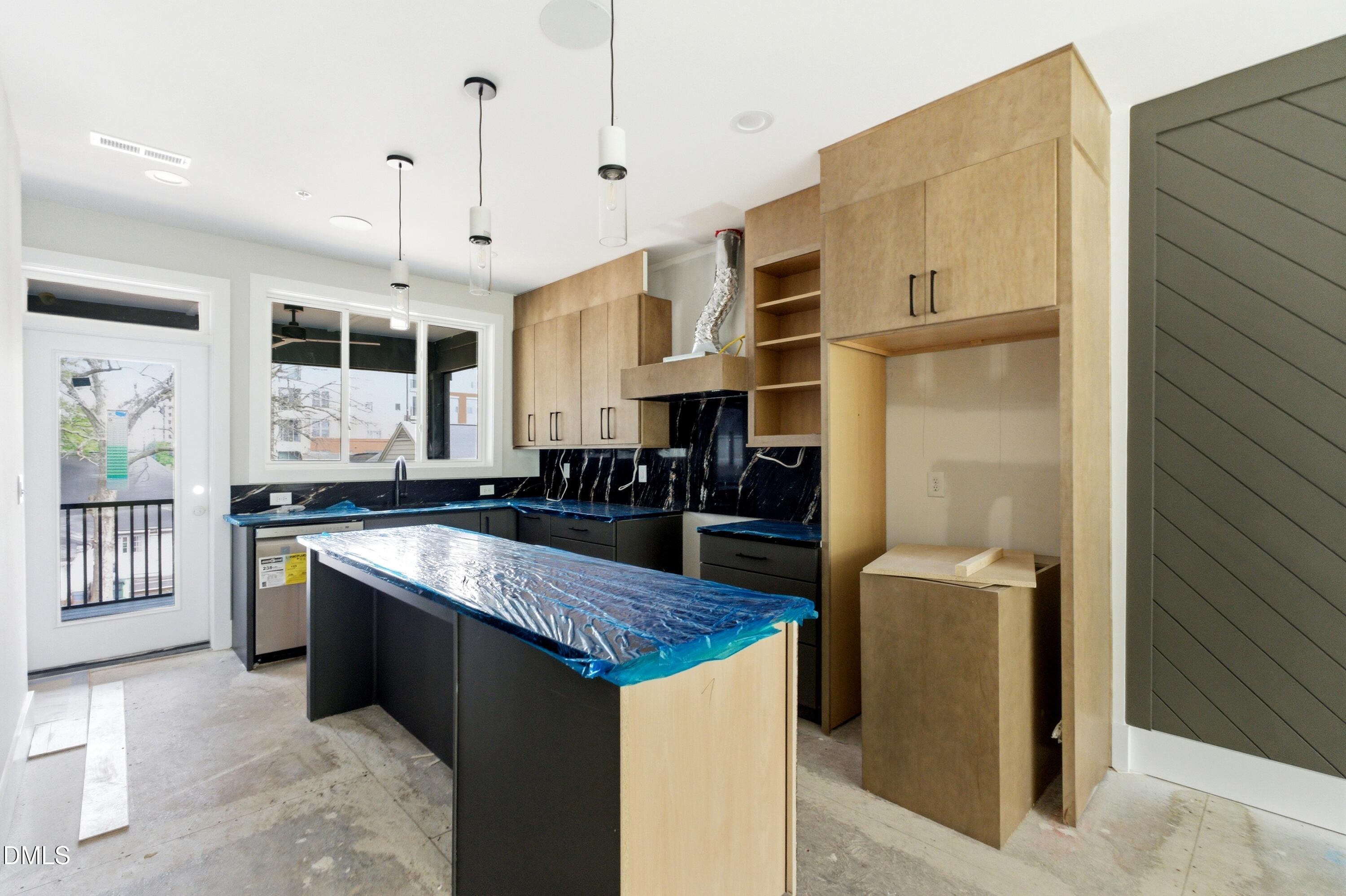720 Noble Town Way, Unit 105 Raleigh, NC 27603 - Photo 5 of 23 This gourmet kitchen features black marble details, custom cabinetry to the ceiling, stainless steel appliances, a large center island with barstool seating, and open to all living, dining and entertaining areas.
