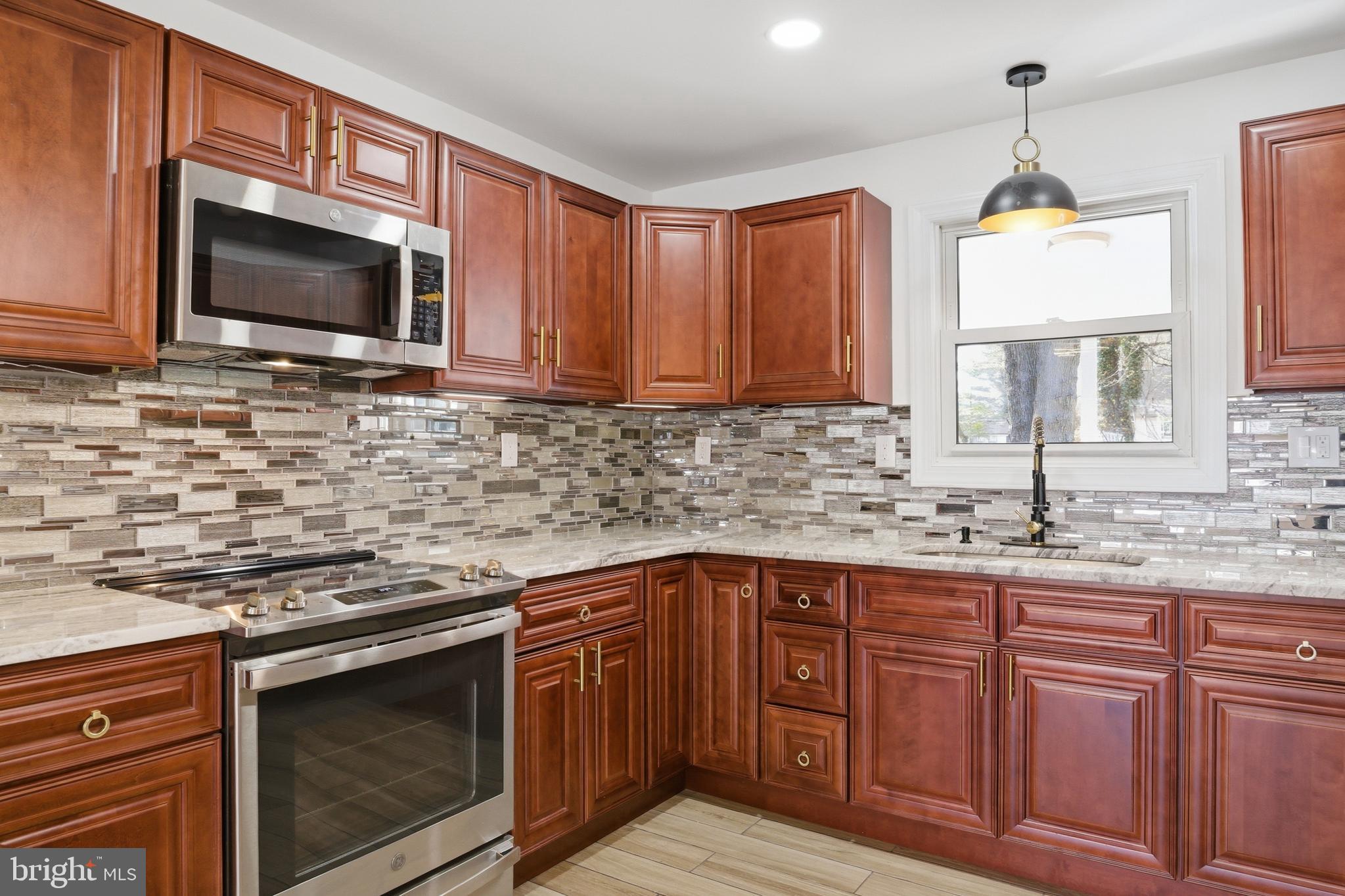 443 High Street Woodbury, NJ 08096 - Photo 8 of 28 a kitchen with stainless steel appliances granite countertop a sink stove and microwave