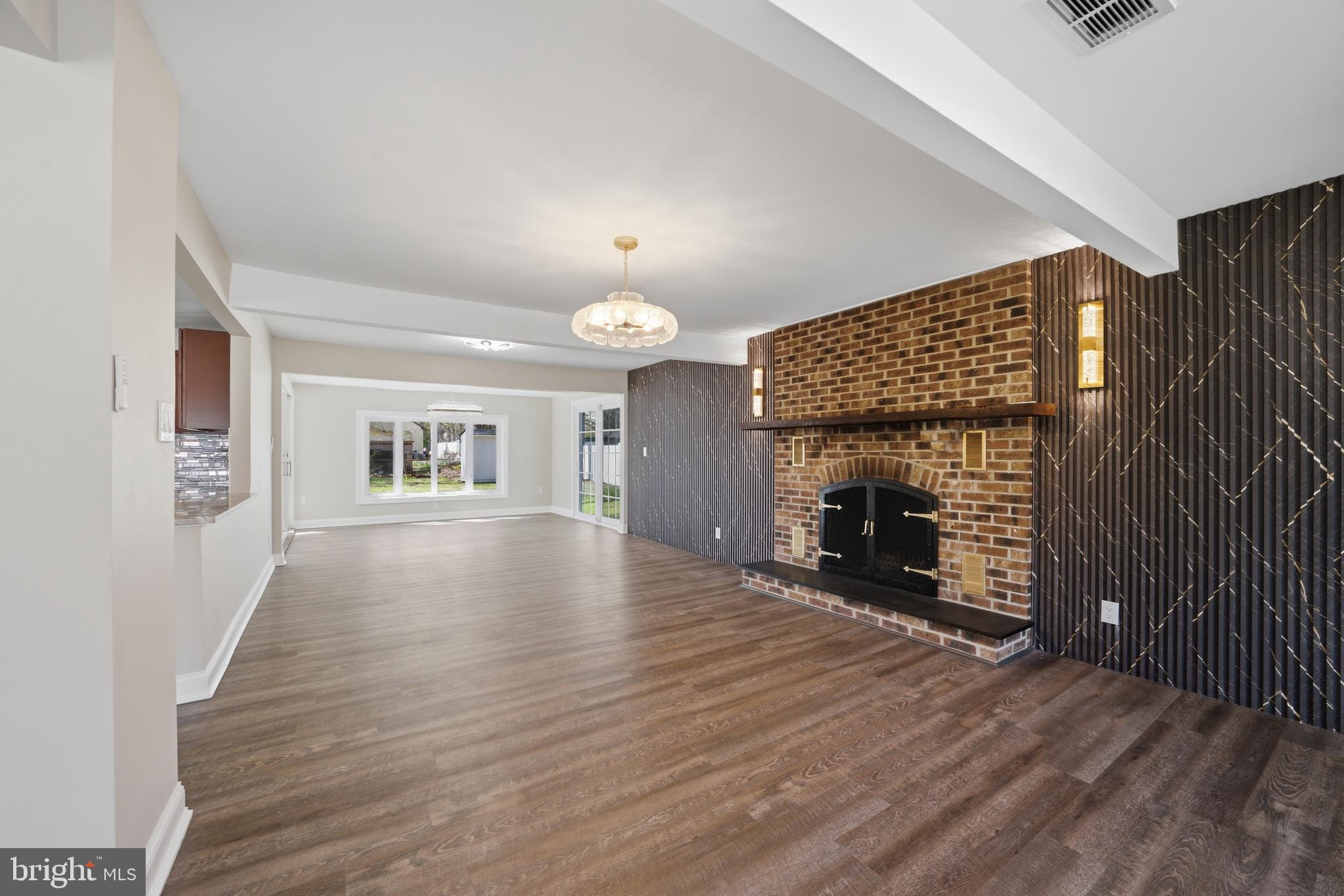 443 High Street Woodbury, NJ 08096 - Photo 10 of 28 an empty room with wooden floor fireplace and windows