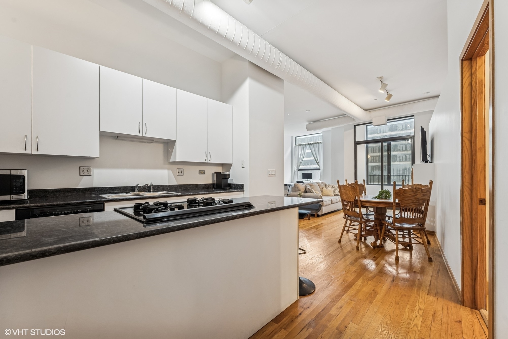 910 South Michigan Avenue, Unit 710 Chicago, IL 60605 - Photo 3 of 17 a kitchen with stainless steel appliances granite countertop a stove and white cabinets with wooden floor