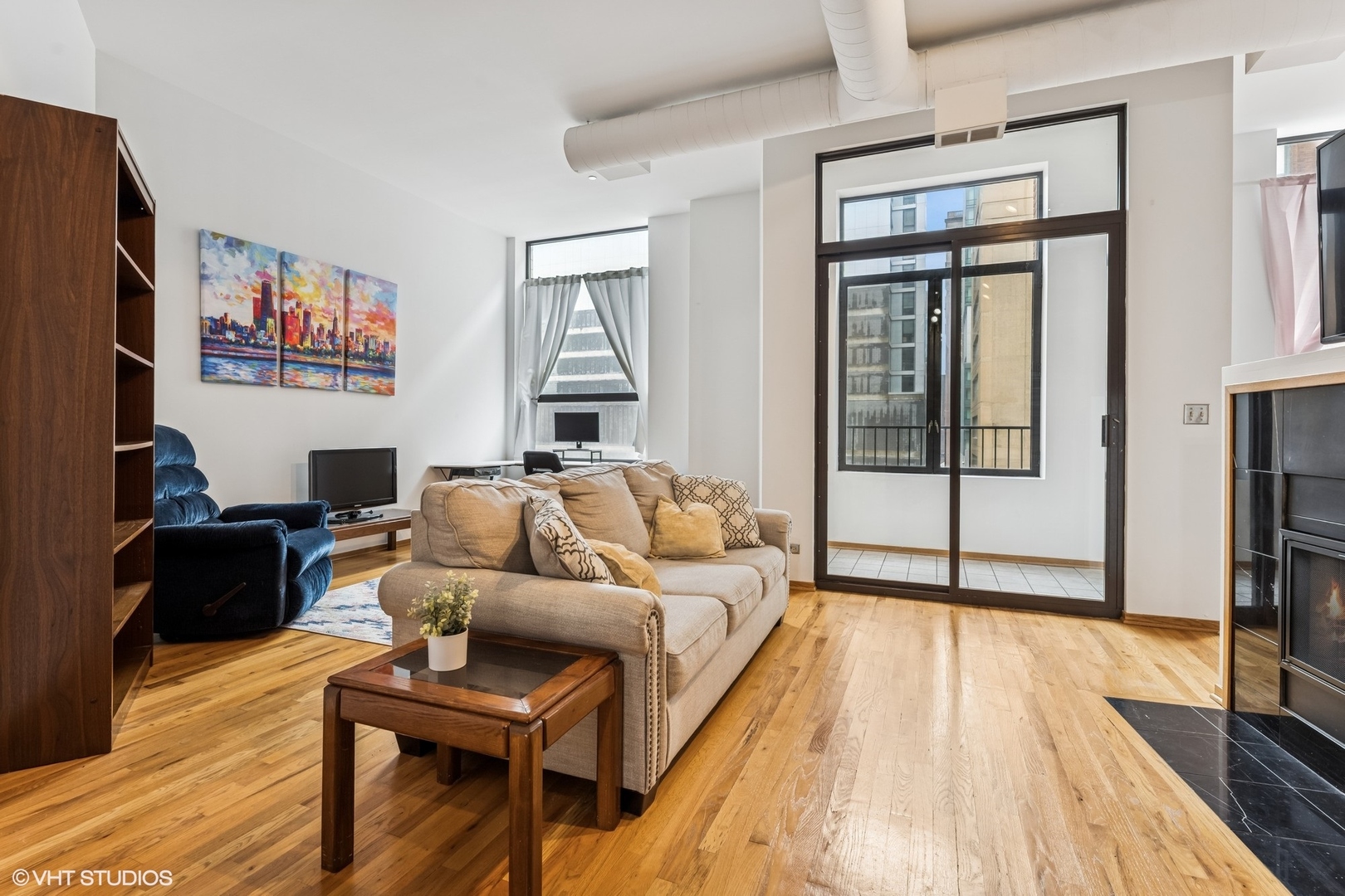 910 South Michigan Avenue, Unit 710 Chicago, IL 60605 - Photo 5 of 17 a living room with furniture and a wooden floor