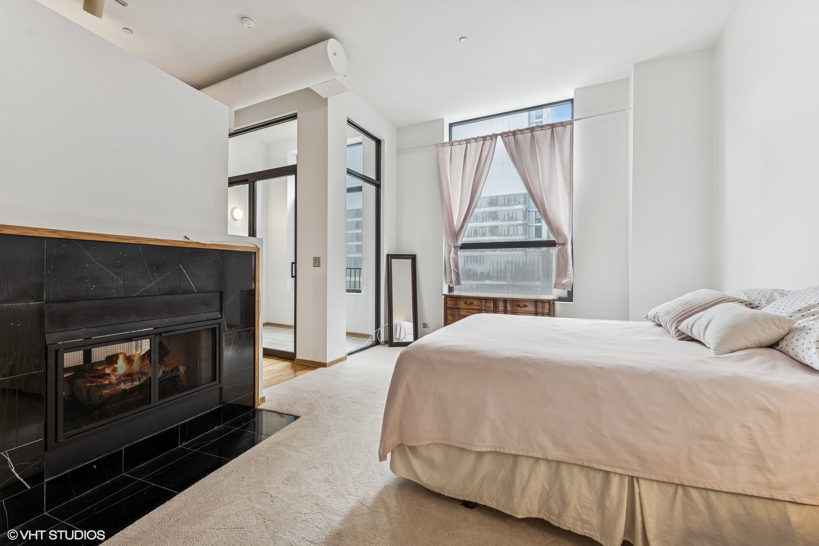 910 South Michigan Avenue, Unit 710 Chicago, IL 60605 - Photo 8 of 17 a bedroom with a bed and a fireplace