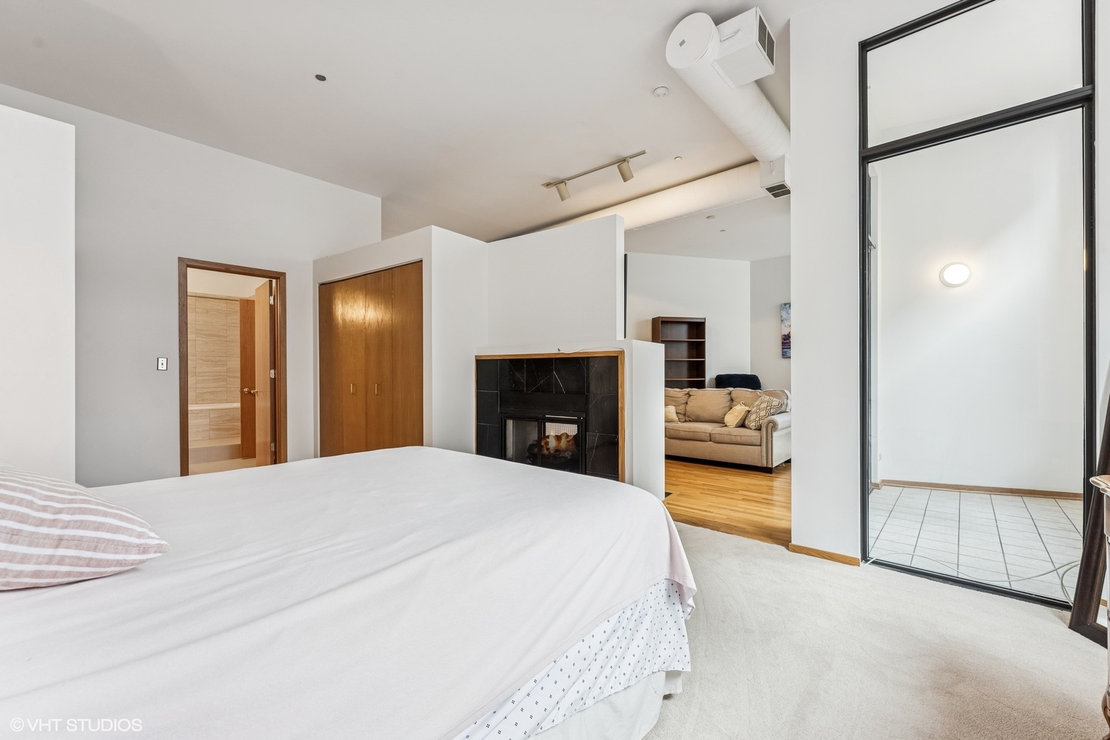 910 South Michigan Avenue, Unit 710 Chicago, IL 60605 - Photo 9 of 17 a bedroom with a bed and a fireplace