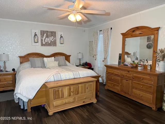a bedroom with a bed and a mirror on dresser
