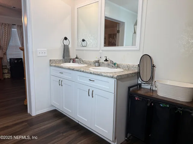 a bathroom with a granite countertop sink a mirror and vanity