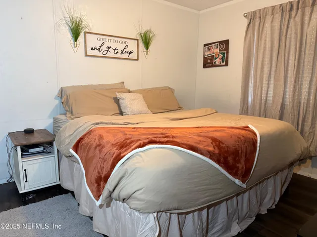 a bed sitting in a bedroom next to a window