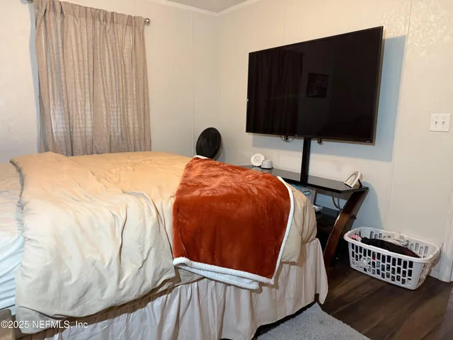 a bed sitting in a bedroom and tv