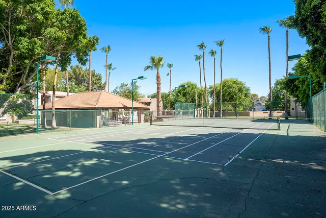 a outdoor view of a house with basket ball court tables and chairs