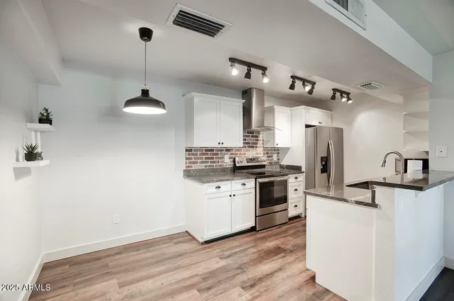 a kitchen with refrigerator cabinets and wooden floor