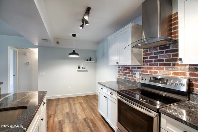 a kitchen with a stove and a wooden floor