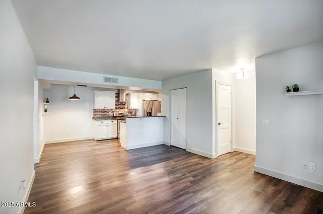 a view of kitchen with refrigerator and wooden floor