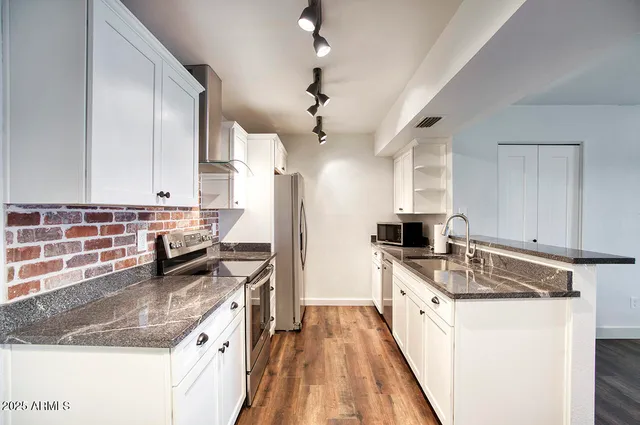 a kitchen with stainless steel appliances granite countertop a sink stove and refrigerator