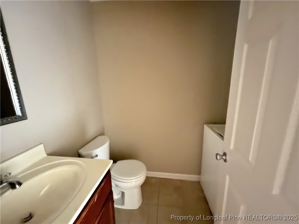 229 Lansdowne Road Fayetteville, NC 28314 - Photo 11 of 18 a white toilet sitting next to a white sink and vanity