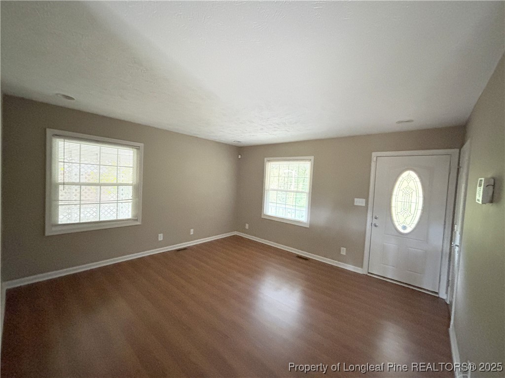 229 Lansdowne Road Fayetteville, NC 28314 - Photo 5 of 18 an empty room with wooden floor and windows