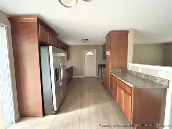 a kitchen with stainless steel appliances granite countertop a refrigerator and a stove