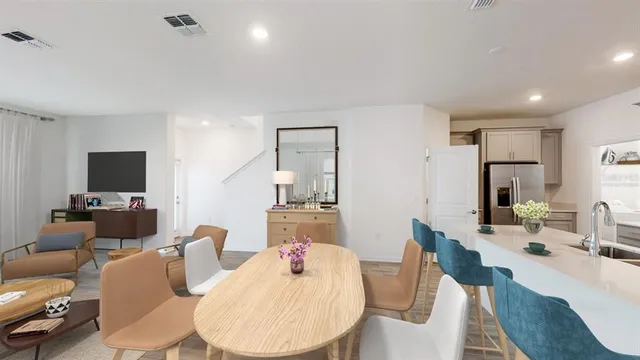 a living room with furniture a flat screen tv and kitchen view