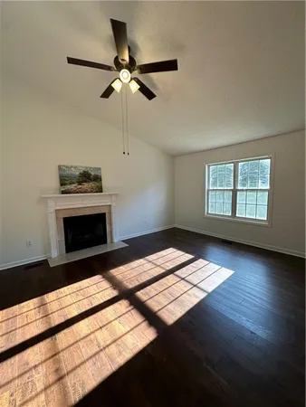 a view of wooden floor fireplace and windows in a room