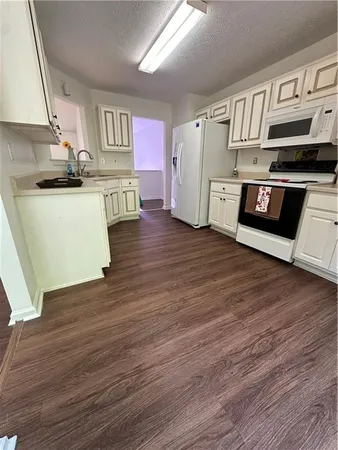 a view of kitchen with wooden floor and electronic appliances