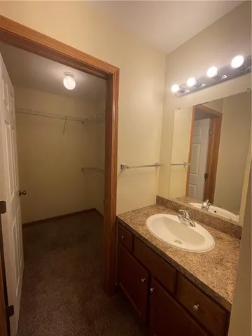 a bathroom with a granite countertop toilet sink and mirror