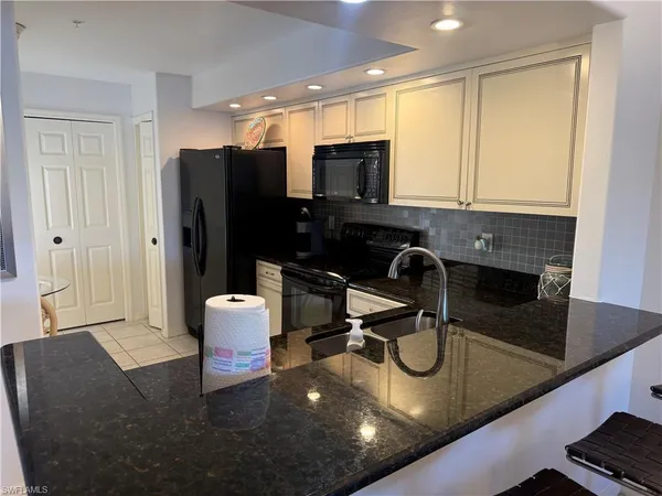 a kitchen with a sink a counter top space cabinets and stainless steel appliances