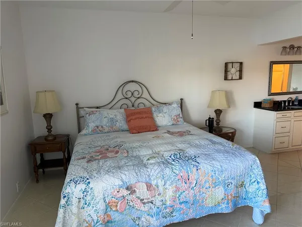 a bedroom with a bed and lamps on dresser