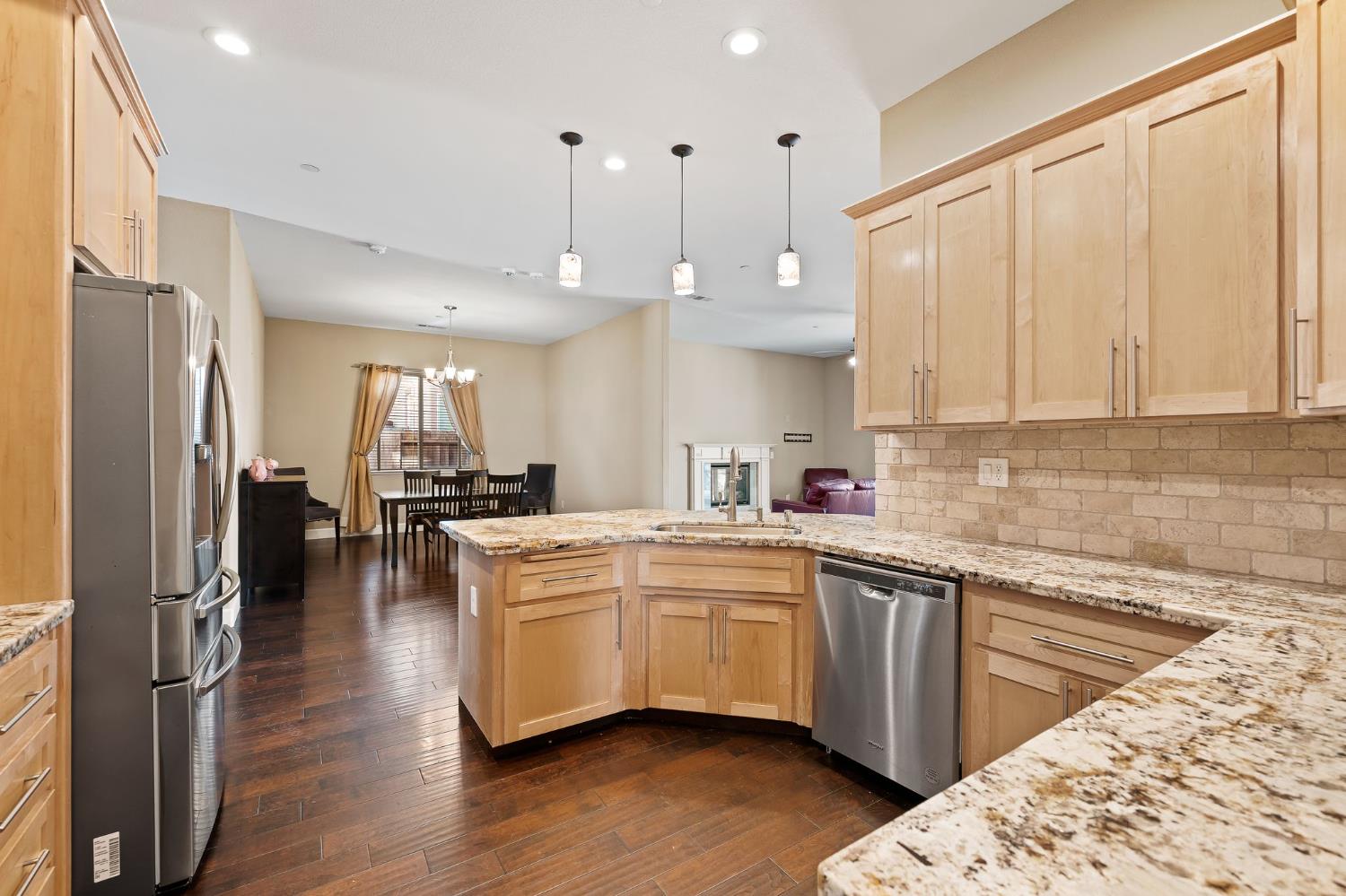 209 Fall Avenue Patterson, CA 95363 - Photo 16 of 48 a kitchen with stainless steel appliances kitchen island granite countertop a refrigerator a sink dishwasher a stove and white cabinets with wooden floor
