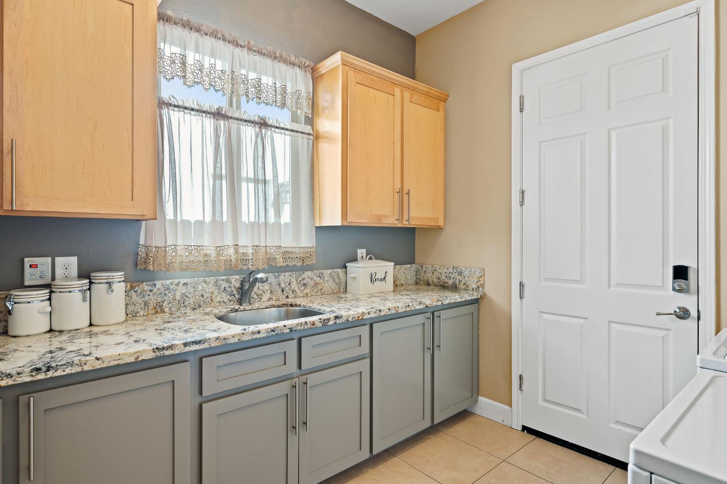 209 Fall Avenue Patterson, CA 95363 - Photo 18 of 48 a kitchen with a sink a cabinets and window