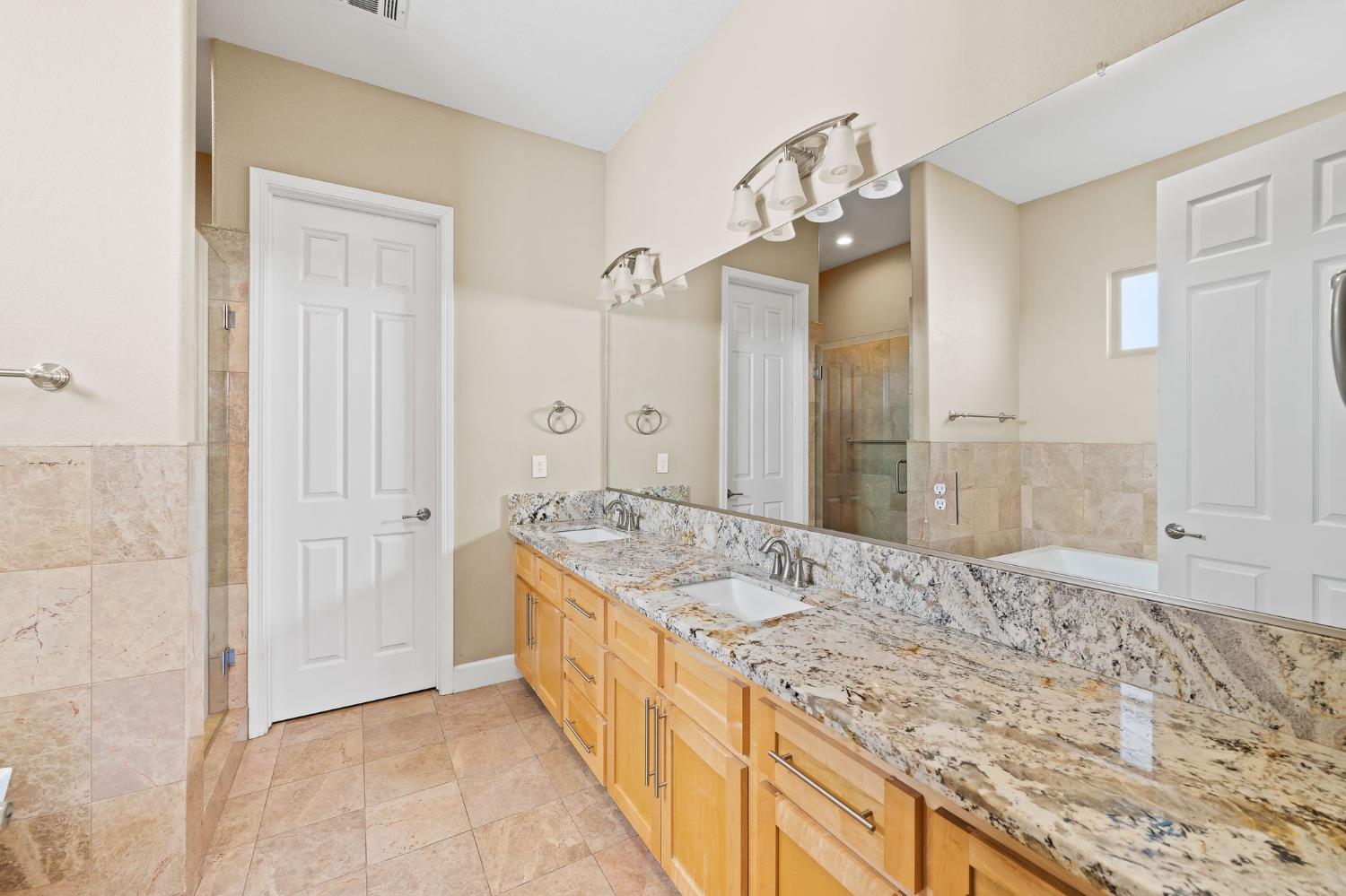209 Fall Avenue Patterson, CA 95363 - Photo 29 of 48 a bathroom with a granite countertop sink and a mirror