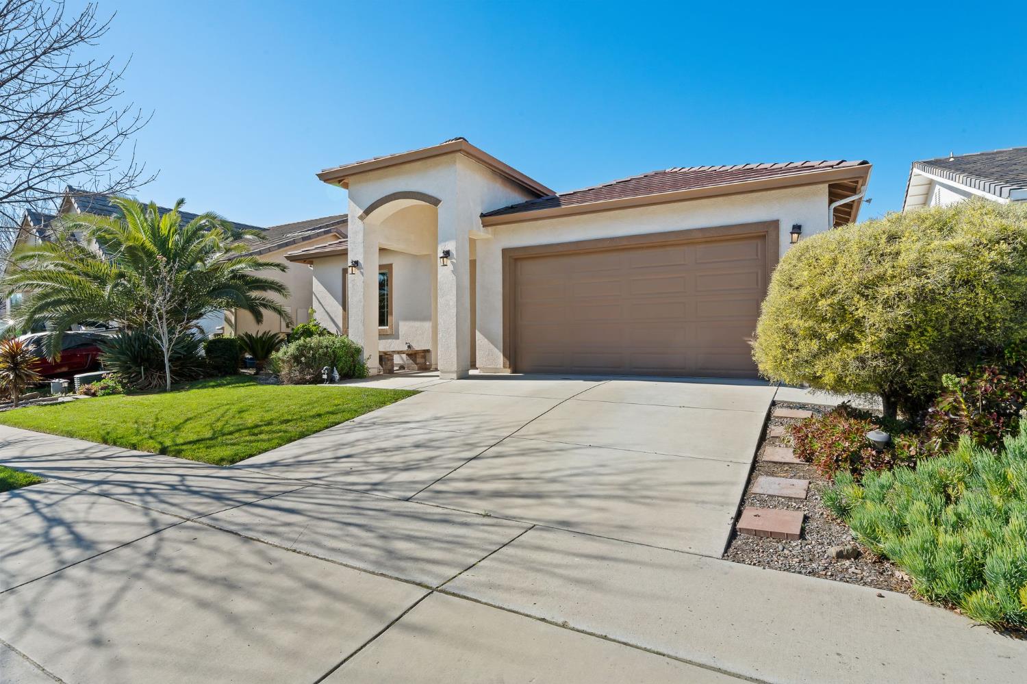 209 Fall Avenue Patterson, CA 95363 - Photo 3 of 48 a front view of a house with a yard and potted plants