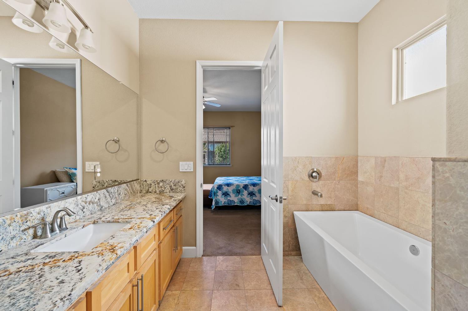 209 Fall Avenue Patterson, CA 95363 - Photo 32 of 48 a en suite bathroom with a granite countertop tub and a large mirror