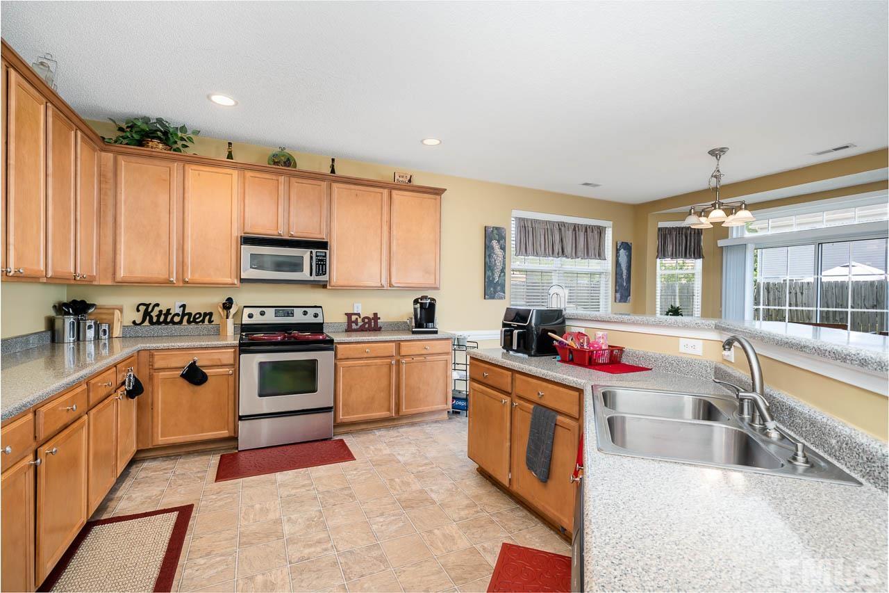 4024 Oatgrass Lane Raleigh, NC 27604 - Photo 5 of 10 a kitchen with stainless steel appliances granite countertop a sink and cabinets