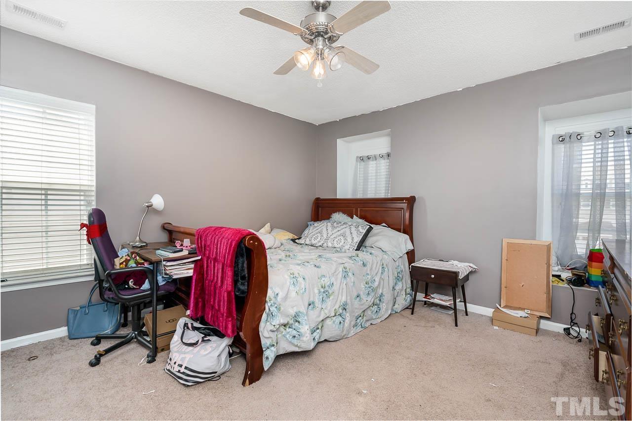 4024 Oatgrass Lane Raleigh, NC 27604 - Photo 7 of 10 a bedroom with a bed and a chandelier