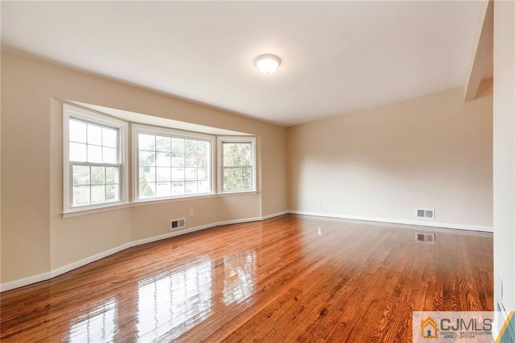 13 Barton Road Old Bridge, NJ 08857 - Photo 11 of 24 an empty room with wooden floor and windows
