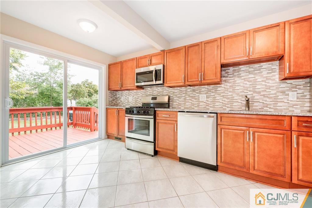 13 Barton Road Old Bridge, NJ 08857 - Photo 12 of 24 a kitchen with stainless steel appliances granite countertop a stove a sink and a microwave