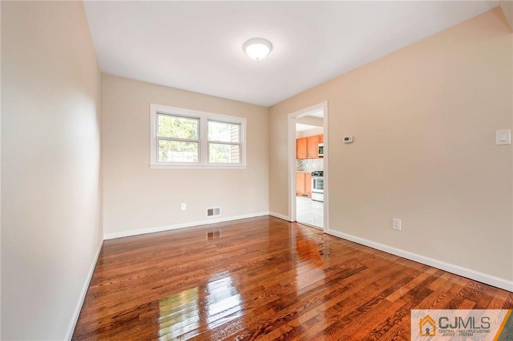 13 Barton Road Old Bridge, NJ 08857 - Photo 7 of 24 an empty room with wooden floor and windows