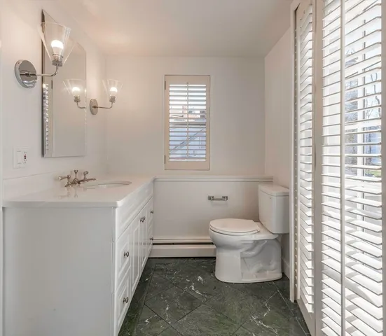 a view of a hallway with wooden floor and windows
