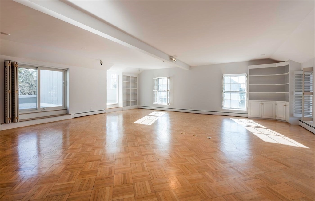 21 Central Street, Unit 1 Manchester, MA 01944 - Photo 6 of 24 a view of an empty room with a window and wooden floor