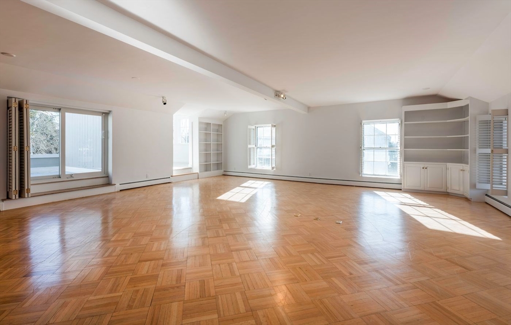 21 Central Street, Unit 1 Manchester, MA 01944 - Photo 8 of 24 a view of an empty room with a window and wooden floor
