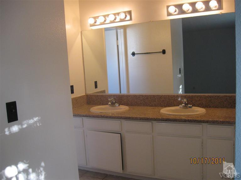 1151 Rivas Lane Oxnard, CA 93035 - Photo 8 of 11 a bathroom with a granite countertop sink and a mirror