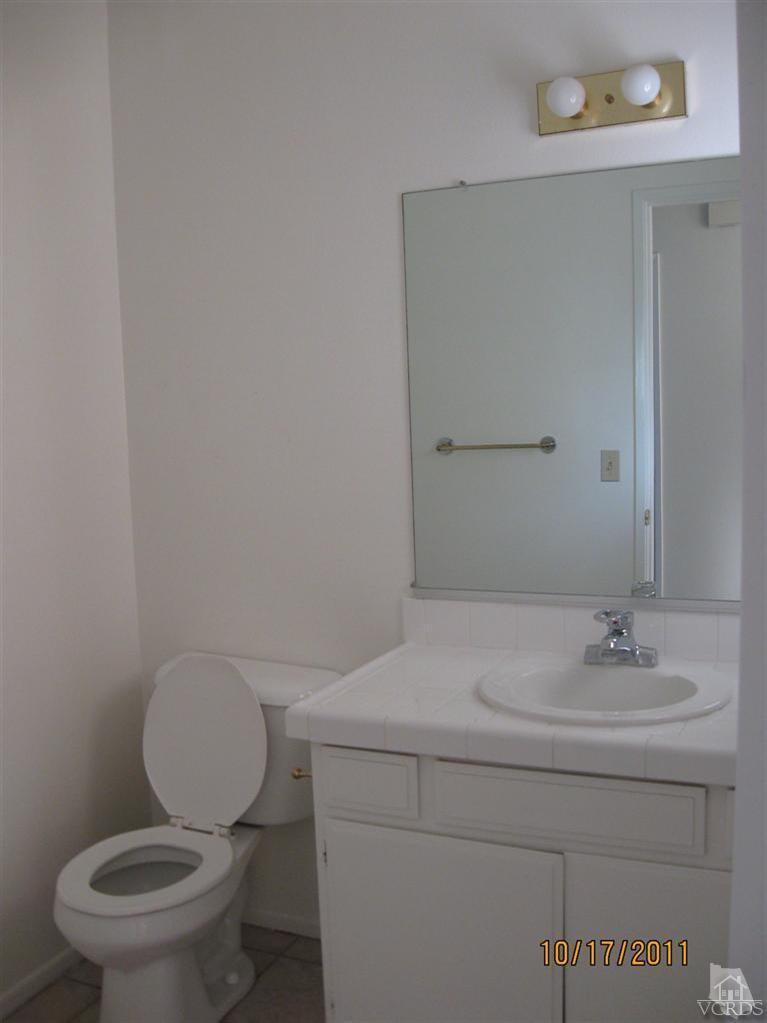 1151 Rivas Lane Oxnard, CA 93035 - Photo 10 of 11 a bathroom with a toilet a sink and mirror