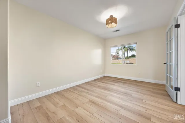 a kitchen with a refrigerator and white cabinets