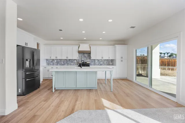 a large kitchen with stainless steel appliances kitchen island granite countertop a large island in the center