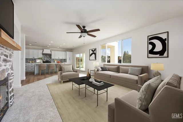 a view of a livingroom with a fireplace a ceiling fan and windows