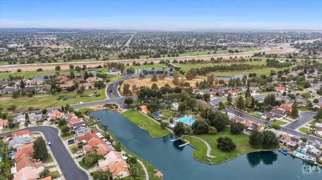 an aerial view of a city with lots of residential buildings ocean and mountain view in back