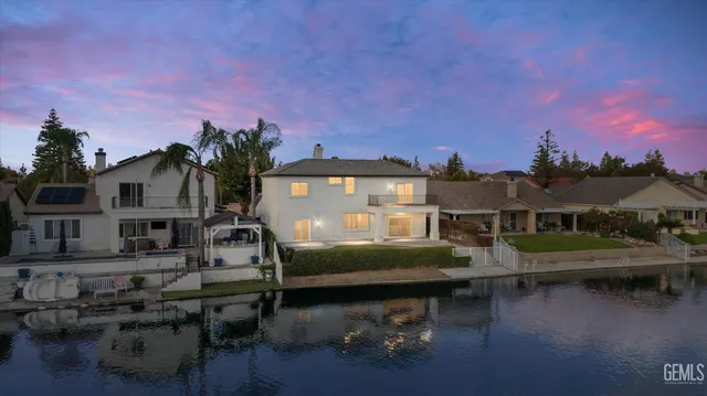a front view of a house with swimming pool and a chairs