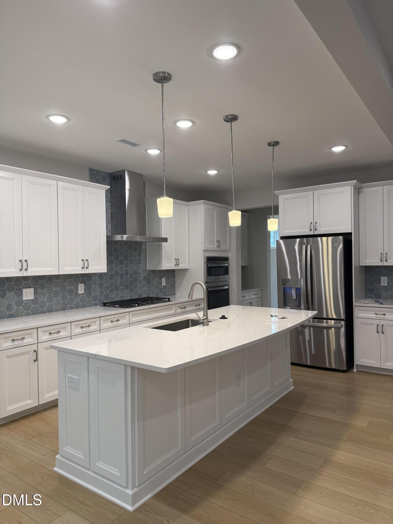 2416 Picual Way Apex, NC 27502 - Photo 2 of 17 a large kitchen with stainless steel appliances kitchen island a stove a refrigerator a sink and a oven