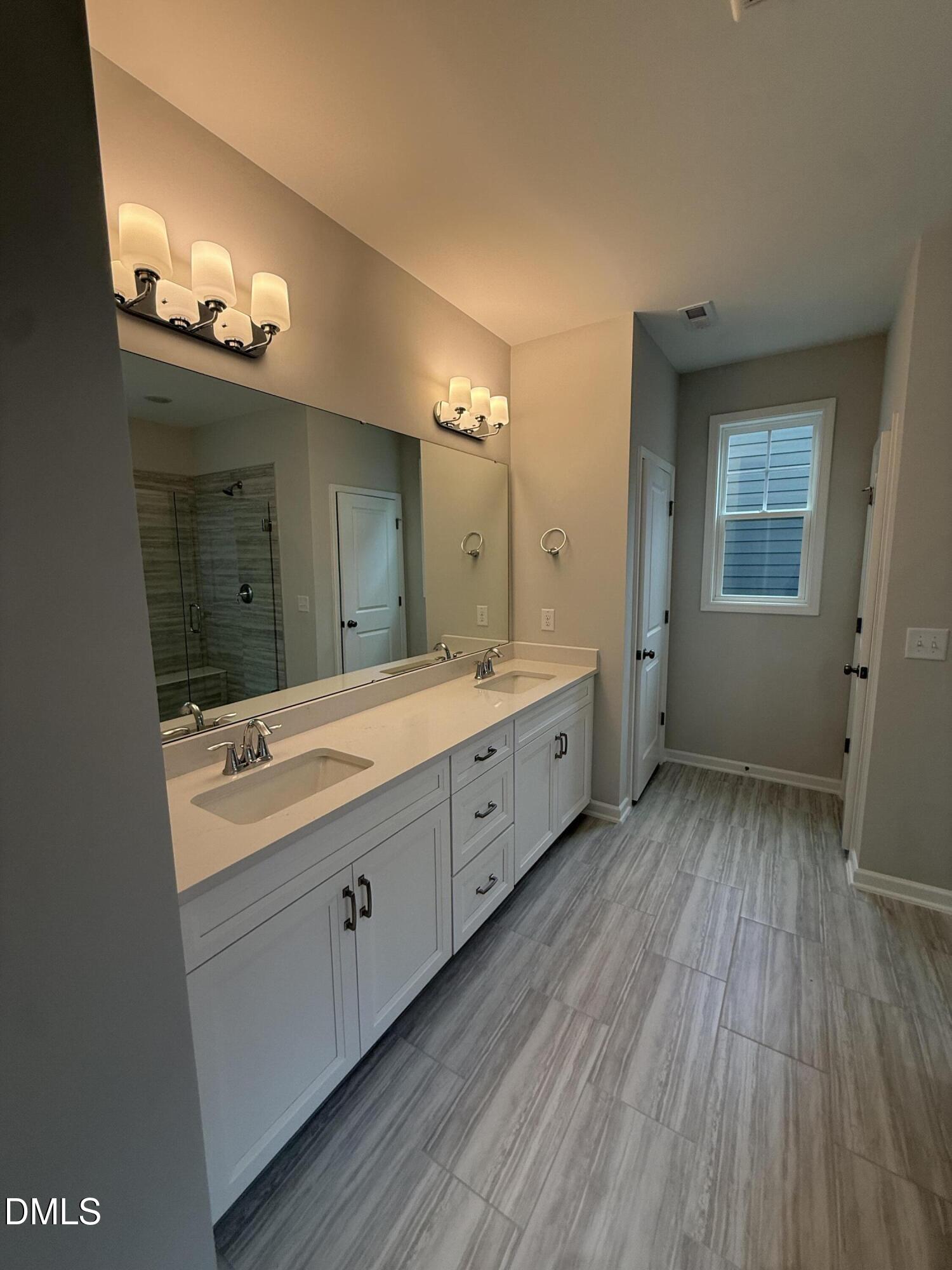 2416 Picual Way Apex, NC 27502 - Photo 10 of 17 a spacious bathroom with a double vanity sink and mirror