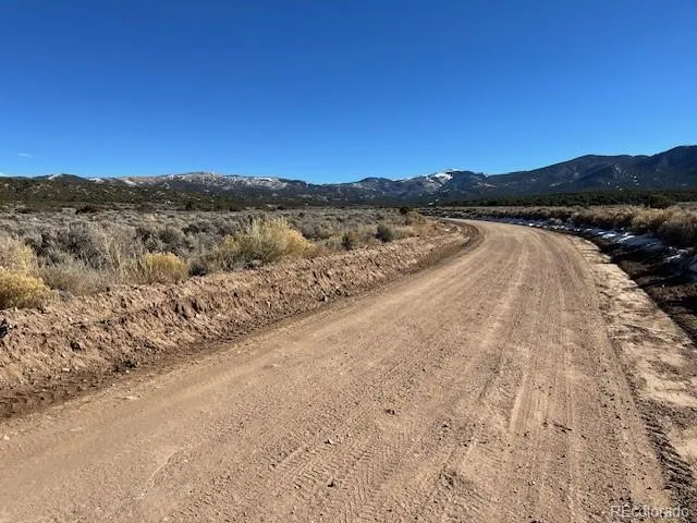 a view of a dry yard with mountains in the background