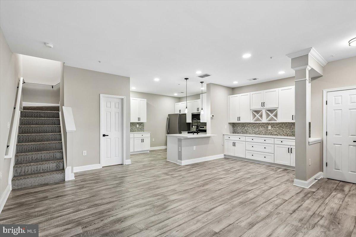 8737 Autumn Ridge Court Odenton, MD 21113 - Photo 11 of 46 a kitchen with stainless steel appliances kitchen island wooden floors and white cabinets